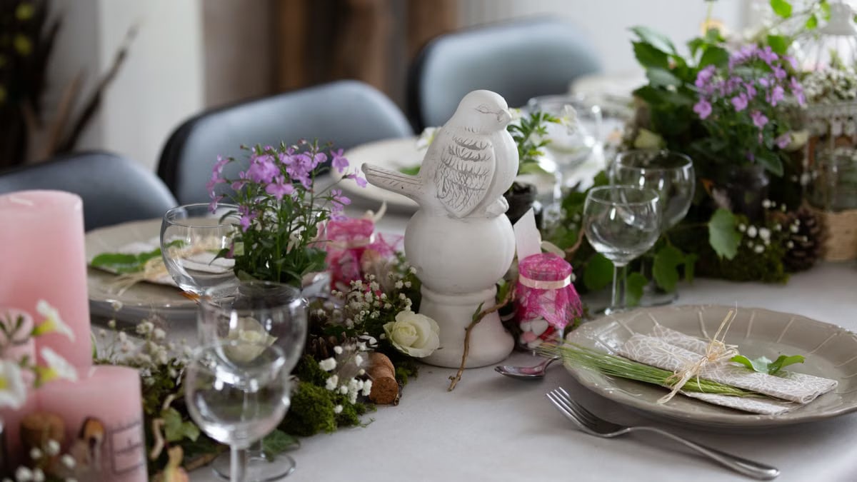 A beautifully arranged dining table with floral centerpieces and elegant tableware.